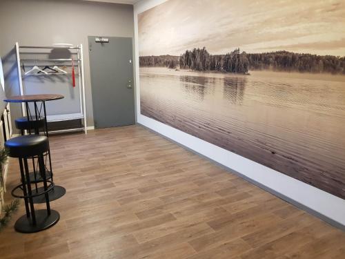 a room with a wall with a painting of a lake at Brukshotellet Skinnsberg in Skinnskatteberg
