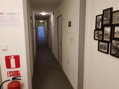 a hallway with a long corridor with pictures on the wall at Brukshotellet Skinnsberg in Skinnskatteberg