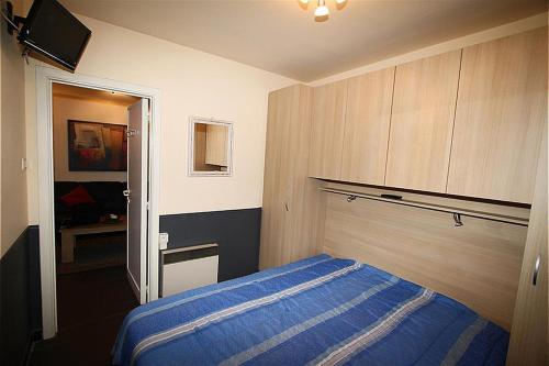 ein Schlafzimmer mit einem blauen Bett in einem Zimmer in der Unterkunft Appartement Dahlia Garden 8p in De Haan