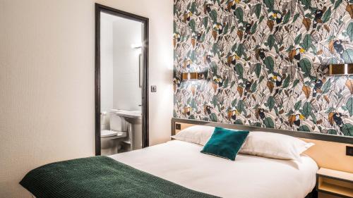 a bedroom with a bed and a wall with a wallpaper at Hôtel Lanjuinais in Rennes