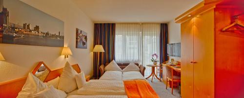 a hotel room with a bed and a desk at Trip Inn Hotel Zum Riesen Hanau in Hanau am Main