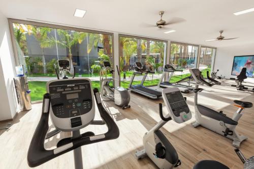 a gym with several treadmills and elliptical machines at Hotel Riu Palace Oasis in Maspalomas
