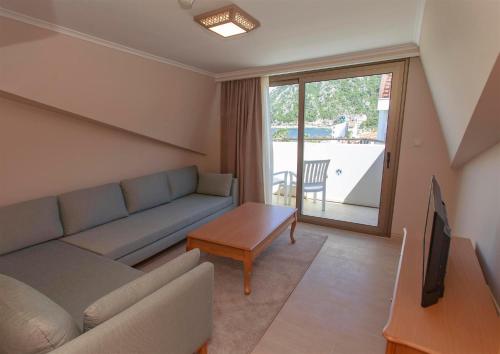a living room with a couch and a tv at Hotel Aqua in Marmaris