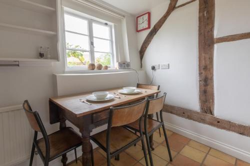 a dining room with a wooden table and chairs at Beggar's Lane Cottage in Winchester