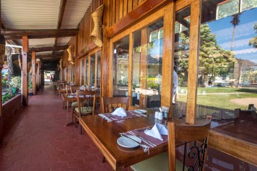 un restaurant avec des tables et des chaises en bois ainsi que des fenêtres dans l'établissement Sunbird Nkopola, à Chipoka