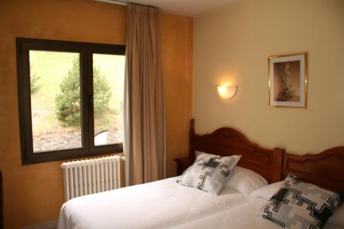 um quarto com 2 camas e uma janela em Hotel Sucara em Ordino