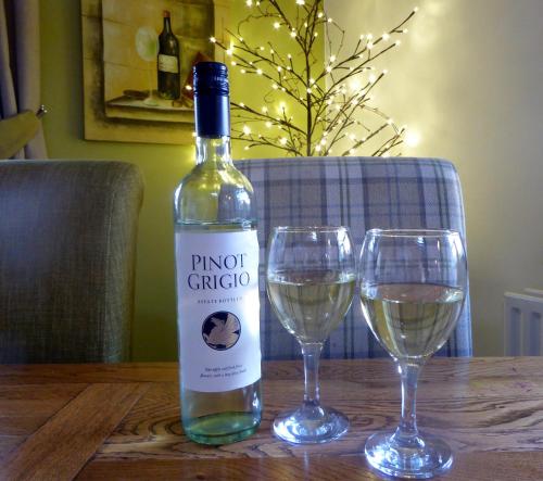 a bottle of wine and two glasses on a table at The Old Ginn House Inn in Great Clifton