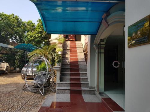 un edificio con una escalera con toldo azul en Khách sạn Anh Đào, en Phủ Lý