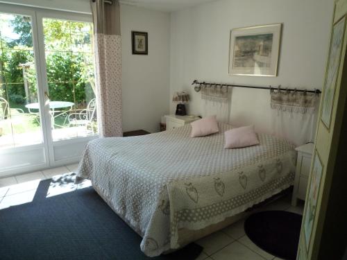 a bedroom with a bed with pink pillows on it at Le Verger du Sausset in Beaune