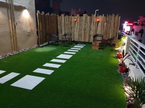 a patio with green grass and chairs on it at Liza Regency in Chennai