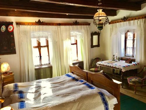 a bedroom with a bed and a cross on the wall at Count Kálnoky's Transylvanian Guesthouses in Micloşoara