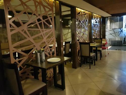 a dining room with tables and chairs and a wall at Liza Regency in Chennai