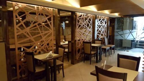 a dining room with tables and chairs in a restaurant at Liza Regency in Chennai