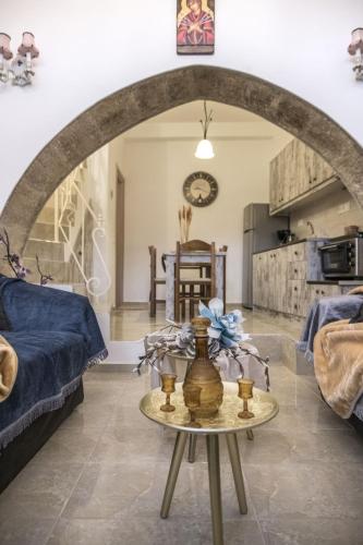 a living room with a table in the middle of a room at Studio Galatia, in the heart of Kamilari in Kamilari