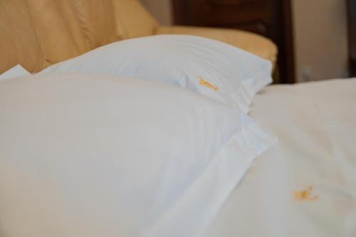 a close up of a white bed with two pillows at Kamelot in Kyiv