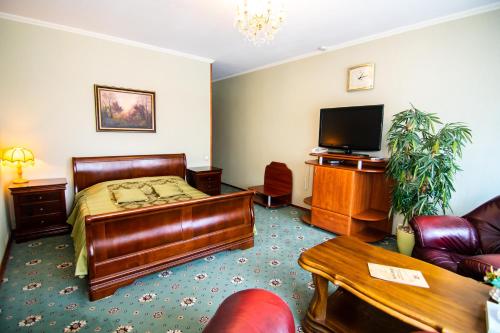 a hotel room with a bed and a flat screen tv at Kamelot in Kyiv