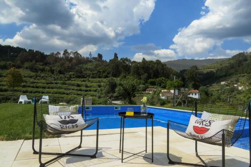 a patio with a table and chairs next to a swimming pool at Quinta São José - Museu do Triciclo in Mesão Frio