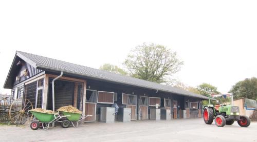 a tractor parked in front of a building with manure at Groepsboerderij 20 pers. in Voorthuizen
