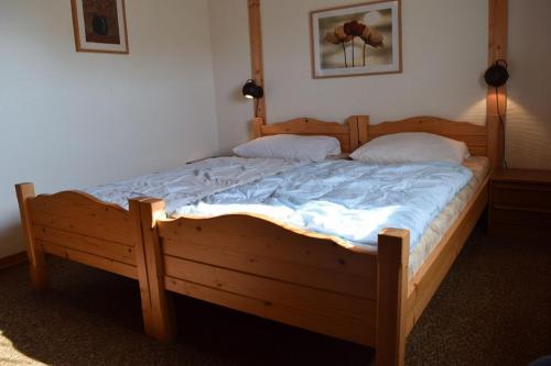 1 dormitorio con 1 cama de madera con 2 almohadas en Holiday park- Robinson, en Waldbrunn