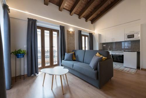 a living room with a blue couch and a table at Old Town Flats Casa Burguerini in Valencia