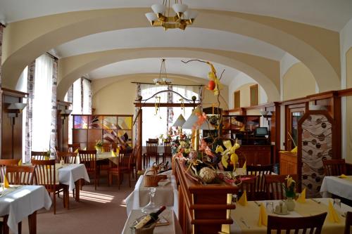 a dining room with tables and chairs and a ceiling at Hotel Havel in Rychnov nad Kněžnou