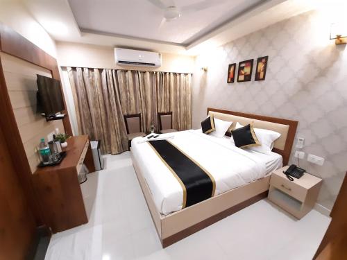 a bedroom with a large bed and a television at Liza Regency in Chennai