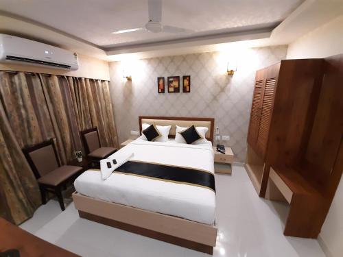 a bedroom with a large bed and a desk and chair at Liza Regency in Chennai