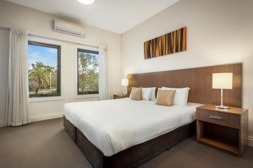 a bedroom with a large bed and a large window at Quest Ipswich in Ipswich