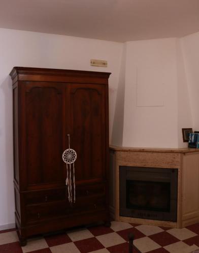 a room with a wooden cabinet and a fireplace at Casa di Emilia in Carpinone