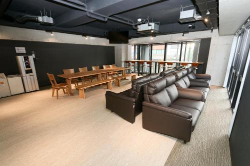 a living room with leather furniture and a table at Capsule Room Lightning Hotel Asakusa in Tokyo