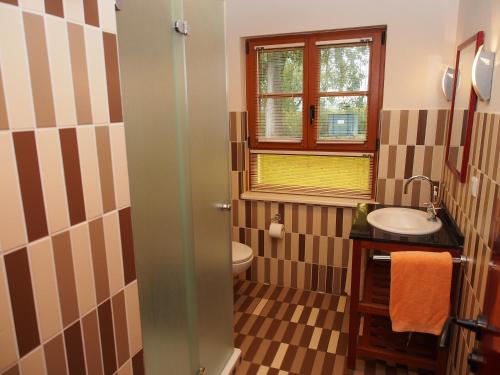 łazienka z umywalką, toaletą i oknem w obiekcie Der Fuchsbau w mieście Meesiger