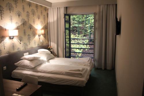 ソポトにあるHotel Leśnyのベッド2台と窓が備わるホテルルームです。