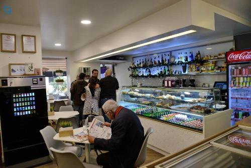 a man is sitting at a counter in a store at Casa Rural Pucariças - Country & Nature in Proença-a-Nova