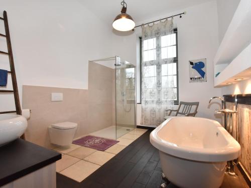 a bathroom with a tub and a shower and a toilet at Ferienwohnung in Steffenshagen mit Terrasse in Steffenshagen