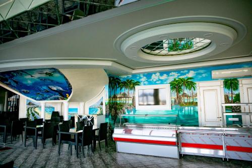 a dining room with palm trees on the walls at Golden Beach in Derbent