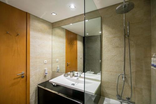 une salle de bain avec lavabo et douche dans l'établissement Comfy Luxury Apartment, à Porto