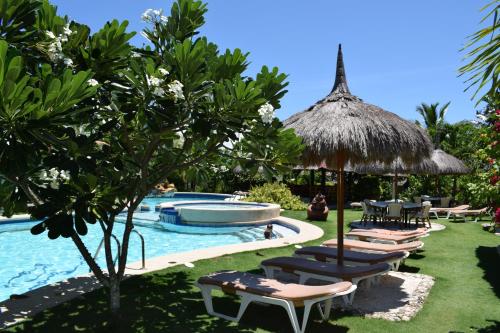 a pool with a bunch of chairs and an umbrella at Dolphin House Resort Moalboal in Moalboal