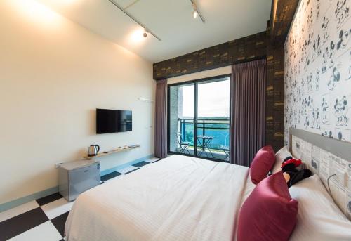 a bedroom with a bed and a large window at Sky Young Homestay in Hengchun