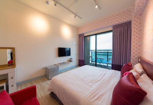 a bedroom with a bed and a large window at Sky Young Homestay in Hengchun