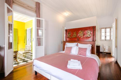 una camera da letto con un grande letto con una coperta rossa e bianca di Villa Marie Lucie a Saint-Denis