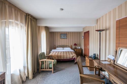 a hotel room with a bed and a desk at Hotel Kopala in Tbilisi City