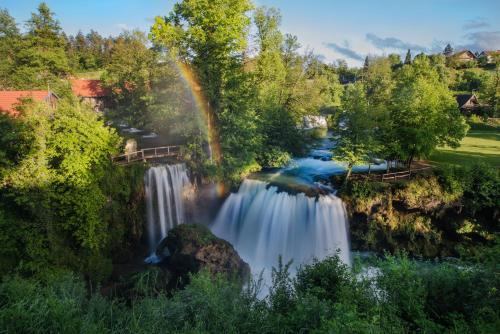 a waterfall with a rainbow in the background at Holiday Home Dandelion with Hot Tub & Sauna in Cetingrad