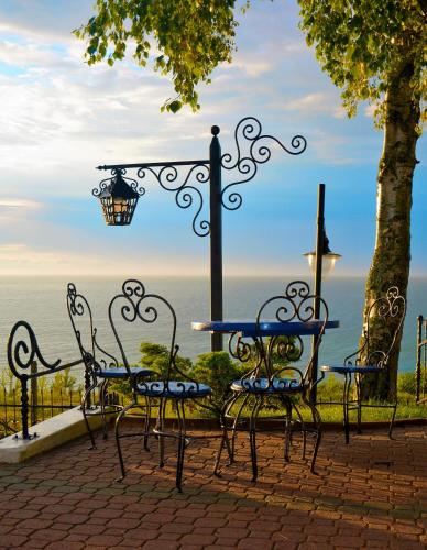 a table and chairs with a lamp and the ocean at Willa Victor in Jastrzębia Góra