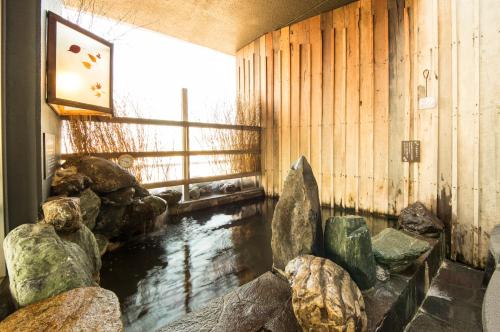 Habitación con un estanque con rocas y una ventana en Dormy Inn Mishima, en Mishima