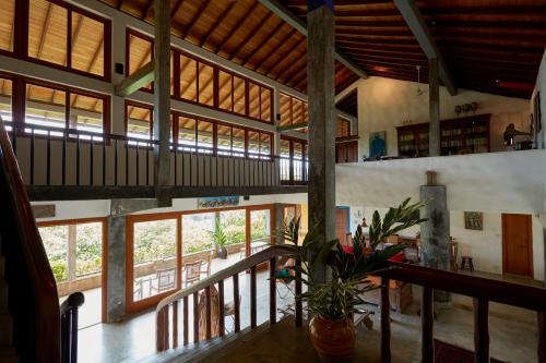 a large room with windows and a plant in a vase at Bamboo Villa Kandy in Digana