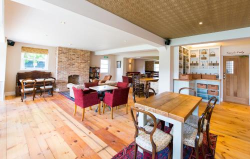 a kitchen and living room with a table and chairs at The Boathouse in Rollesby