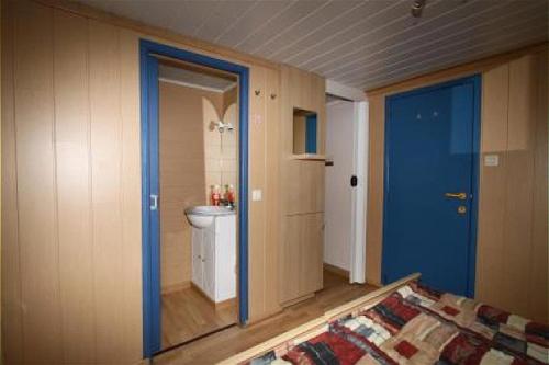 uma casa de banho com WC e uma porta azul em Studio Dahlia 2p em De Haan