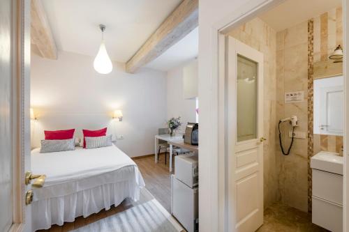 a bedroom with a white bed with red pillows at Vilnius Apartments in Vilnius