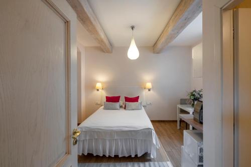 a bedroom with a white bed with red pillows at Vilnius Apartments in Vilnius