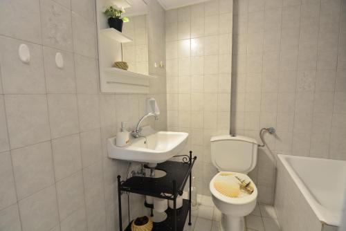 een witte badkamer met een toilet en een wastafel bij Olea Apartments in Xylokastron